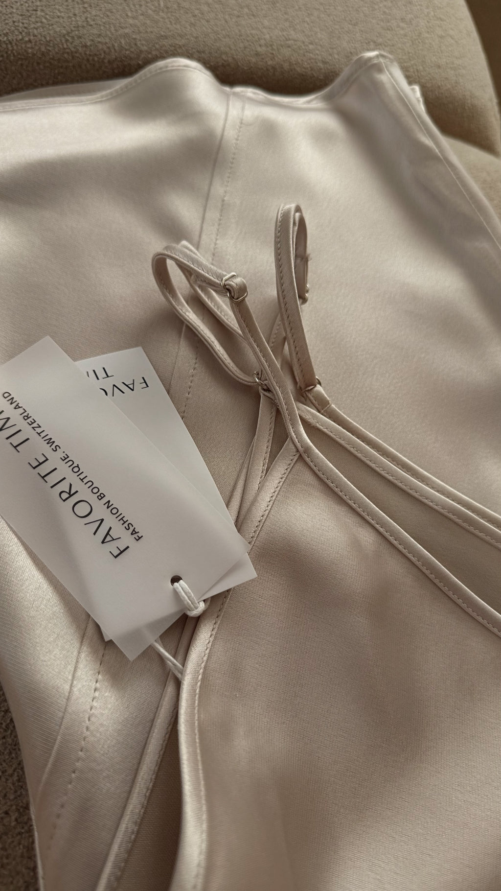 Beige sweatshirt with a tag on a neutral background