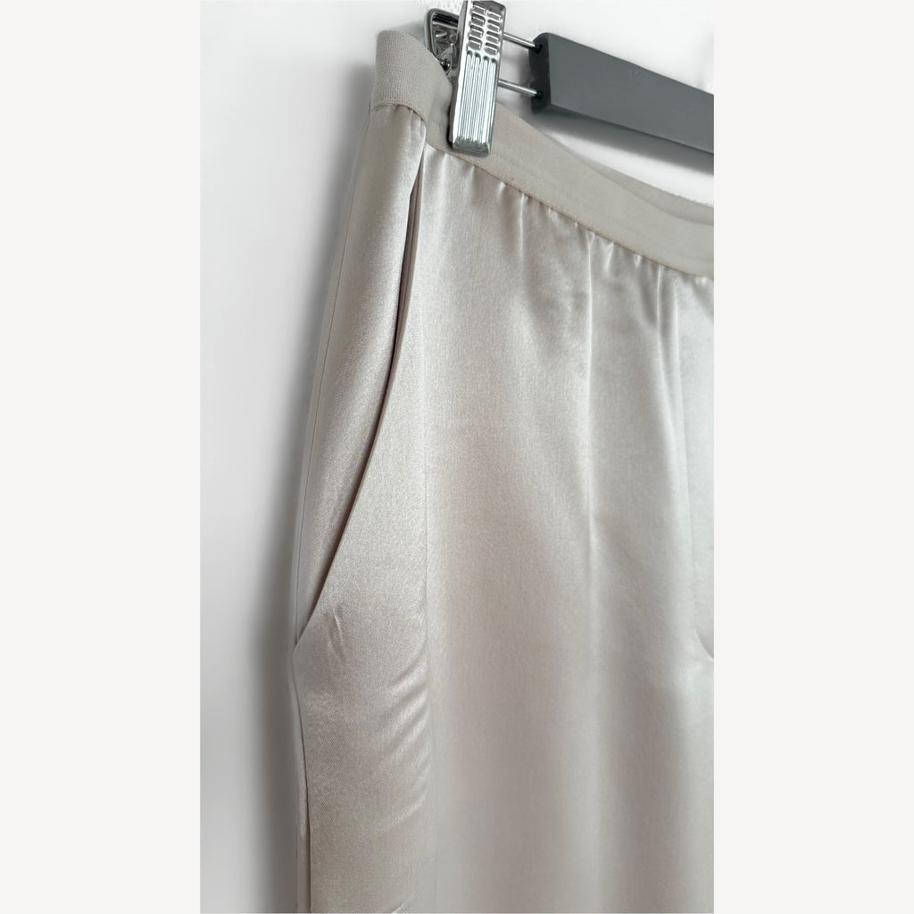 Beige pants on a hanger against a white background